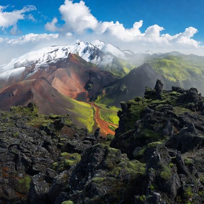 Snow-capped volcano with colorful mountains