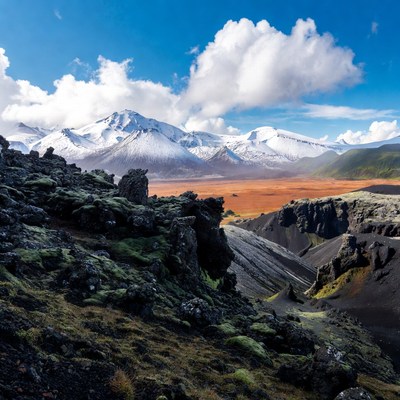 Snowy Mountains Over Volcanic Landscape