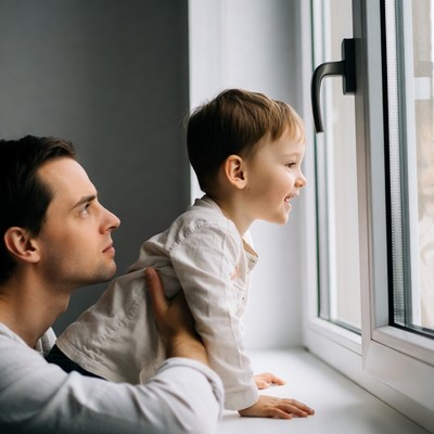 Father lifting toddler to window