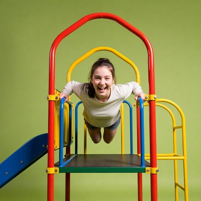 Girl smiling on colorful playground slide