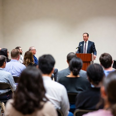 Man speaking at podium to audience