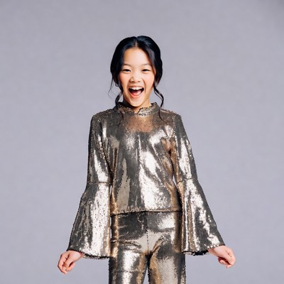 Asian girl smiling in gold sequin outfit
