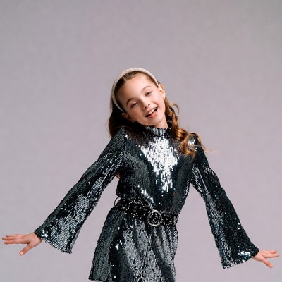 Girl in sequin dress with arms outstretched