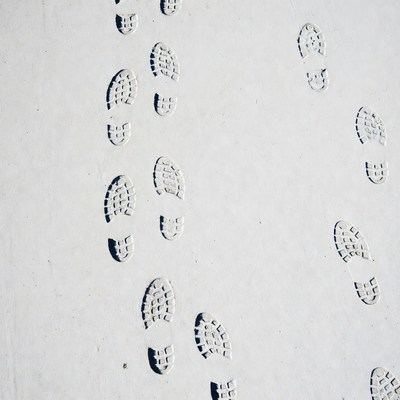 Sneaker footprints on white sand