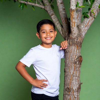 Smiling Latino boy leaning on tree