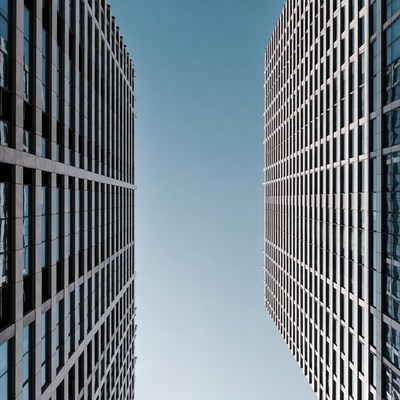 Two Tall Glass Skyscrapers Against Blue Sky