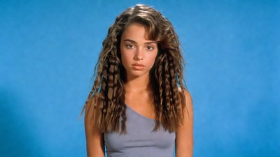 Young woman with curly hair on blue background