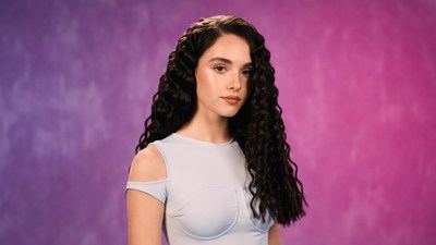 Woman with curly hair on purple background