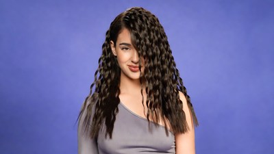Woman with curly hair on blue background