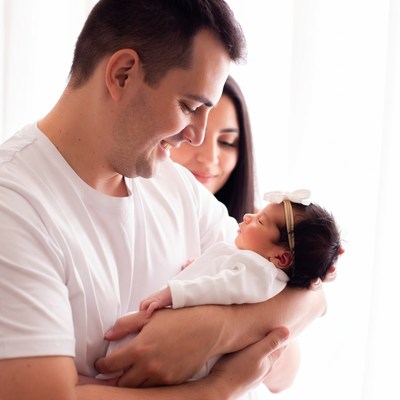 Father holding newborn baby with mother