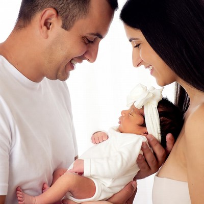 Parents smiling at newborn baby