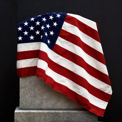 American Flag Draped on Stone Pedestal