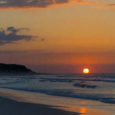 Sunset over beach with ocean waves