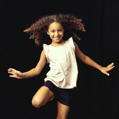 Curly-haired girl dancing on black background