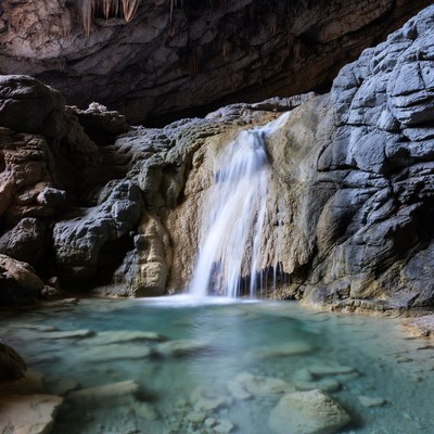 Waterfall in turquoise cave pool