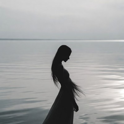 Silhouette of woman by lake