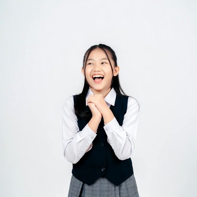 Asian girl smiling excitedly in school uniform