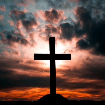 Silhouette Cross in Sunset Sky