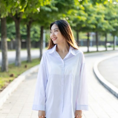 Asian woman smiling in tree-lined park