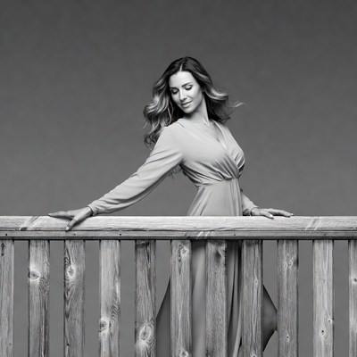 Woman leaning on wooden railing