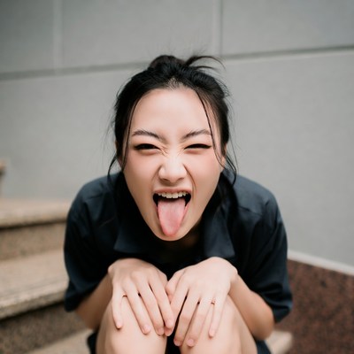 Asian woman sticking tongue out on stairs