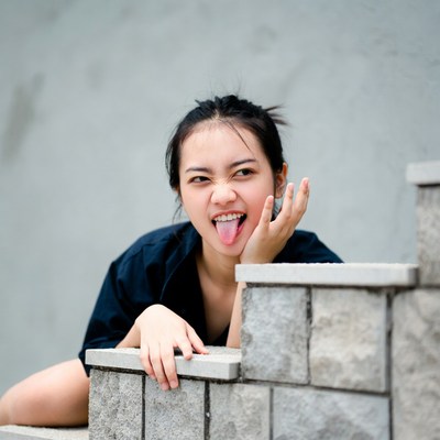 Asian woman sticking tongue out on stairs