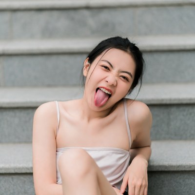 Asian girl sticking tongue out on stairs