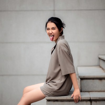 Asian girl sticking tongue out on stairs