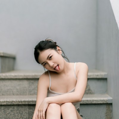 Asian woman sticking tongue out on stairs