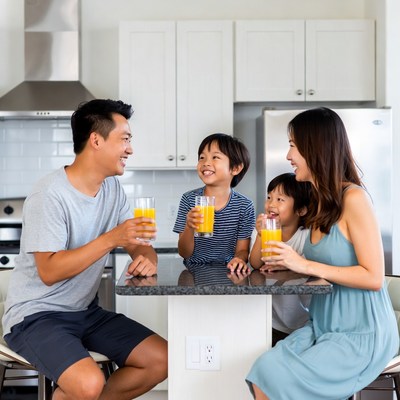Asian family drinking orange juice kitchen