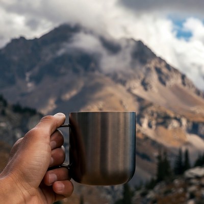 Man holding mug with mountains