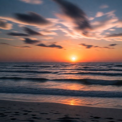 Sunset over beach with footprints