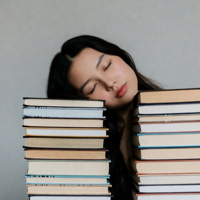 Asian woman sleeping on books