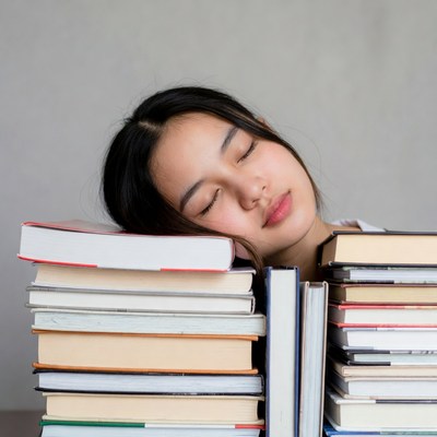 Asian girl sleeping on books