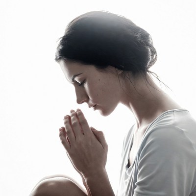 Woman praying with hands clasped