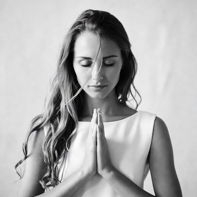Woman praying with hands in namaste