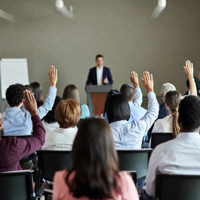 Audience raising hands at conference