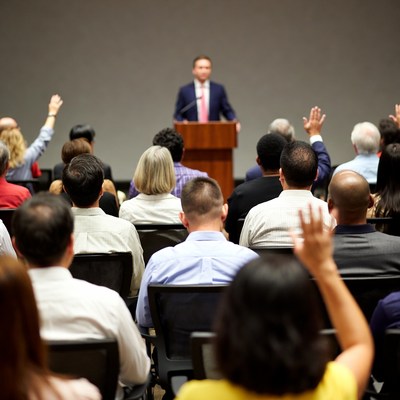 Man speaking at podium with audience