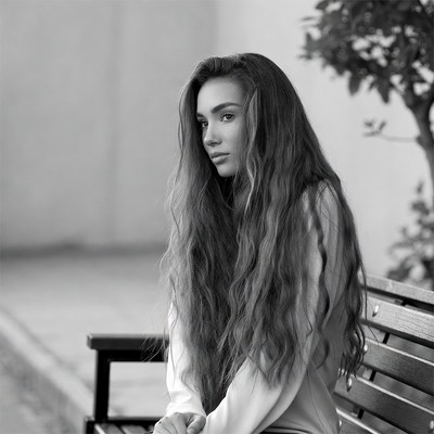 Woman sitting on bench with long hair