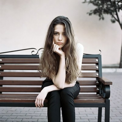 Woman sitting pensively on park bench