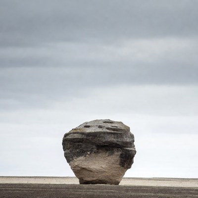 Large rock on sandy ground