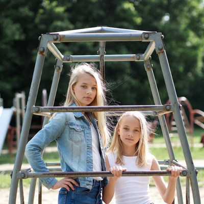 Two blonde girls at playground jungle gym