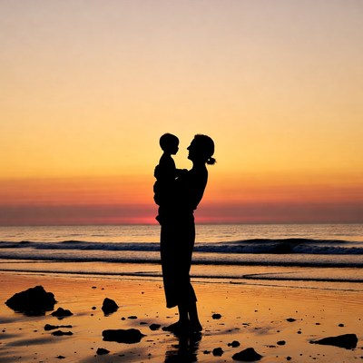 Mother holding child silhouette at sunset beach
