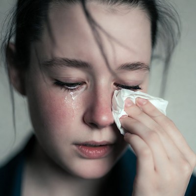 Woman crying holding tissue