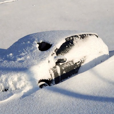 Snow-covered car in deep snow