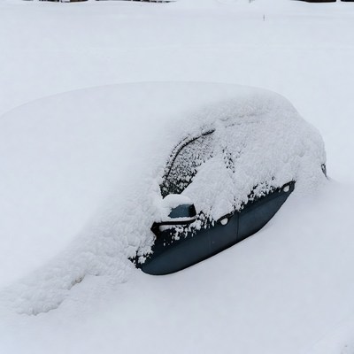Snow-covered car in winter field