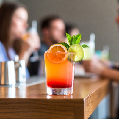 Orange cocktail with lime on bar