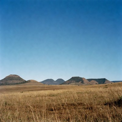 Mesas in Dry Grassland Under Blue Sky
