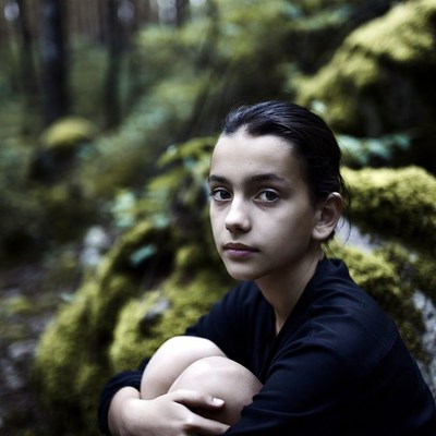 Girl sitting in mossy forest