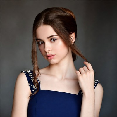 Woman touching hair in blue dress